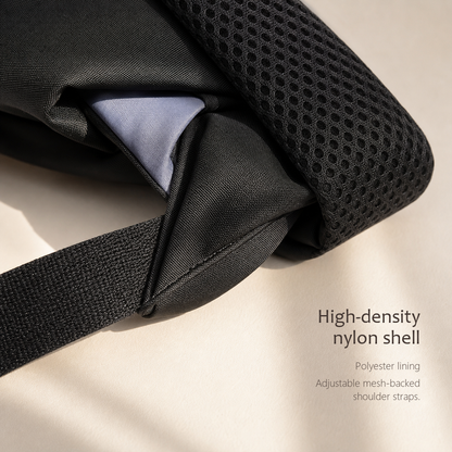 CommuteCore structured laptop backpack in black, close-up of the high-density nylon shell with grey polyester lining and mesh shoulder strap.