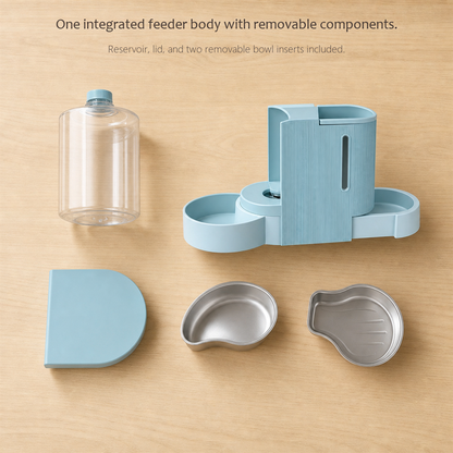 FeedFlow feeder in light blue disassembled on wood: clear reservoir, lid and two removable bowl inserts.