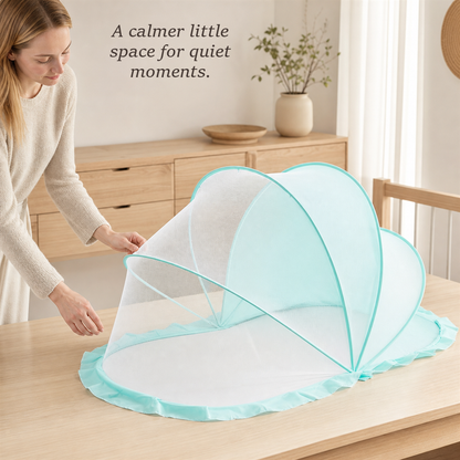 Woman opening the SleepVeil mint green pop-up mesh canopy on a wooden table in a bright bedroom.