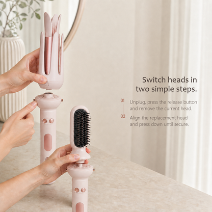 StyleOrbit hair styler in pink, hands lifting the curl head off one handle and fitting a brush head to a second.