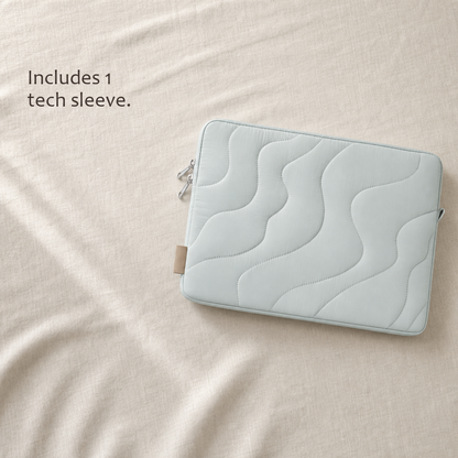 TerraSleeve laptop sleeve in cloud mist, laid on soft cream linen with an Includes 1 tech sleeve label for what's in the box.