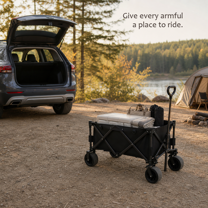 TrailFold wagon in black loaded with a cooler, tote bag and blanket at a lakeside campsite with a tent.