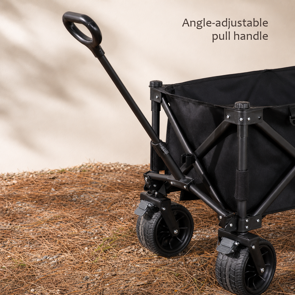 TrailFold wagon in black with its telescoping pull handle raised, close-up on pine-needle ground.