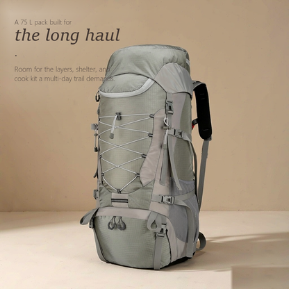 TrailFrame 75L hiking backpack in sage gray-green, three-quarter front view with bungee lacing and mesh side pockets.