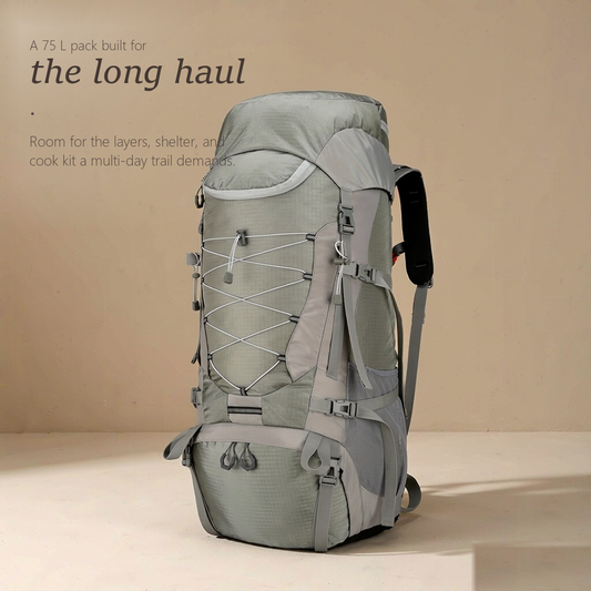 TrailFrame 75L hiking backpack in sage gray-green, three-quarter front view with bungee lacing and mesh side pockets.